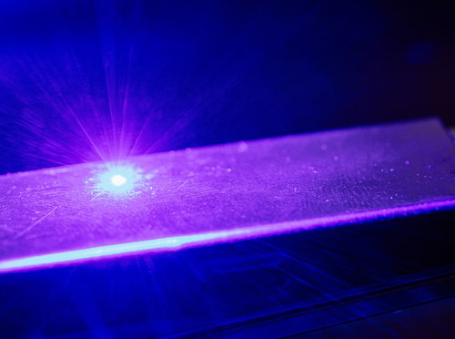 紫色の光線が飛び散るレーザーマーカーを使用中
