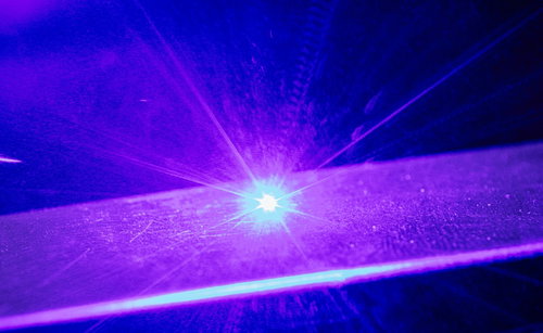 レーザーマーカーで金属に刻印する紫色の光線と火花