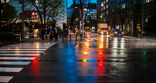 雨上がりの横断歩道に映る信号の灯り