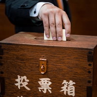 投票用紙を投票箱に入れる市民の一票、民主主義と市民参加の実践の写真