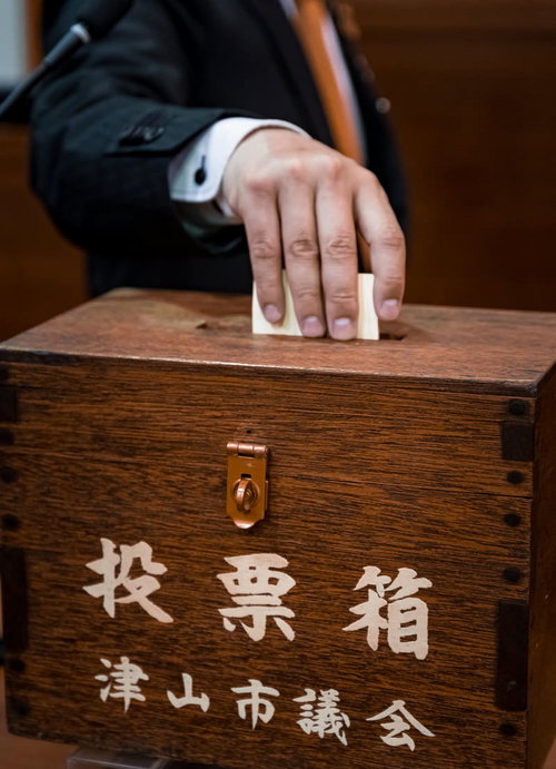 投票用紙を投票箱に入れる市民の一票、民主主義と市民参加の実践