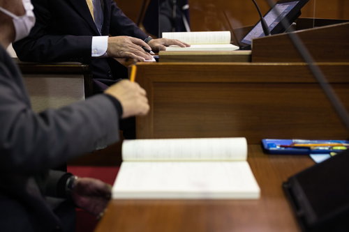 議場で資料を確認する議会事務局長と議長のやり取り