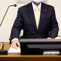 議会の進捗をメモを取りつつ見つめる議長の姿の写真