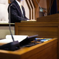 議場内の最も高い位置に設置された議長席で書類を確認する議長の写真