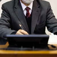 メモを取ろうとしたが鉛筆の持ち方が逆だった議員の写真