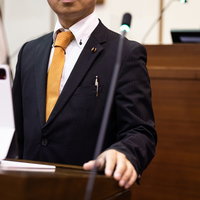 タブレット端末を持って登壇する津山市の議員の写真