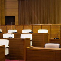 木製デスクとマイクが設置された津山市議会の議場内部の写真
