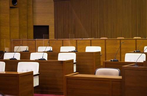 木製デスクとマイクが設置された津山市議会の議場内部