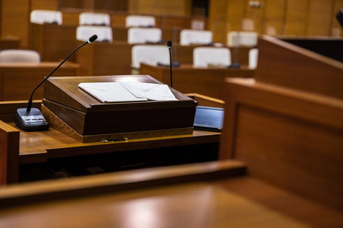 登壇席に置かれたタブレット端末と紙原稿、マイク