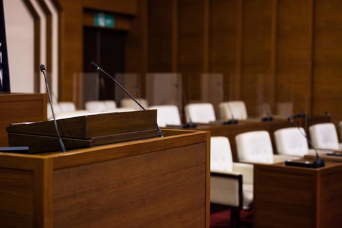 演壇を中心に白い椅子が整然と並んでいる議員席