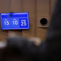 賛成15票、反対10票で可決。市議会の採決結果を映す電光板の写真