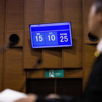 採決の結果を電光板に見守る議員、賛成反対の投票数を確認の写真