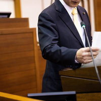 津山市議会で資料を手に演説する議員のスピーチの写真