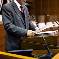 質問原稿を読み上げる津山市議会の議員が議場の演壇で発言の写真