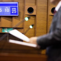 採決結果を電光板で確認する議員の姿 - 地方議会での投票風景の写真