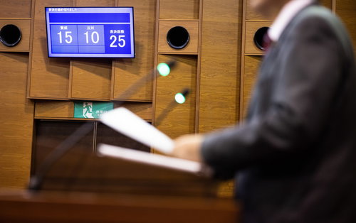 採決結果を電光板で確認する議員の姿 - 地方議会での投票風景