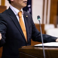 市議会の議場でガッツポーズを決める政治家の写真