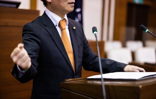 市議会の議場でガッツポーズを決める政治家