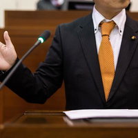 議場で熱弁を振る市議会議員の説明と討論、市政に関する議案審議の写真