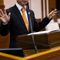 ジェスチャーを交えながら登壇して話す議員の写真