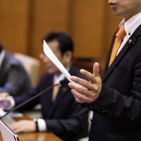 津山市議会で手振りをしながら説明する議員の写真