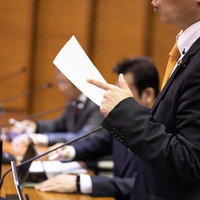 議場で発言する男性議員の写真