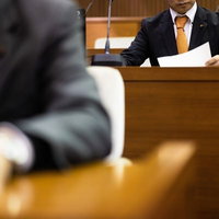 資料をチェックする津山市議会議員の議場での討論風景の写真