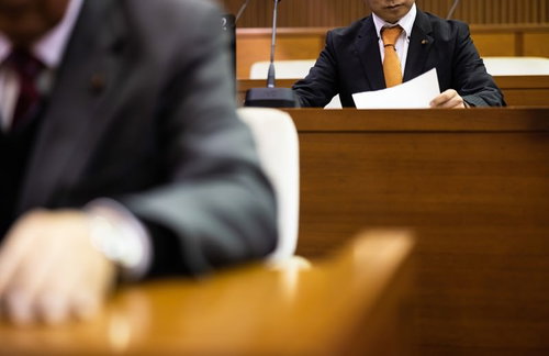 資料をチェックする津山市議会議員の議場での討論風景