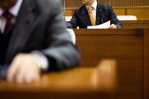 市議会の議場で発言している男性議員