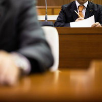 議会資料を確認する津山市議会の議員席での職務風景の写真