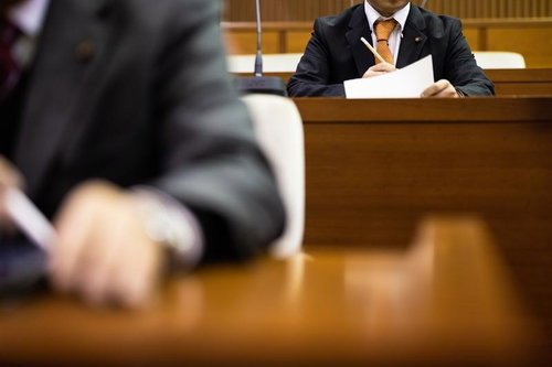 議会資料を確認する津山市議会の議員席での職務風景