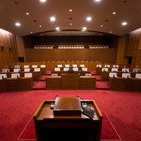 登壇席の上から臨む津山市議会の議場全景と木製議員席の写真