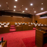 赤いカーペットが敷かれた議場の議員席と報道席、傍聴席の写真