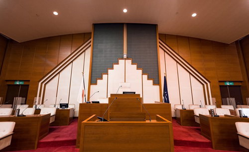 登壇席の後ろに議長席と議会事務局長席が配置された議場の全景