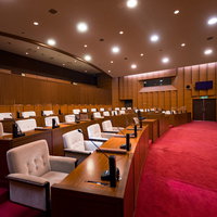 レッドカーペットが敷かれた津山市議会の議場の写真