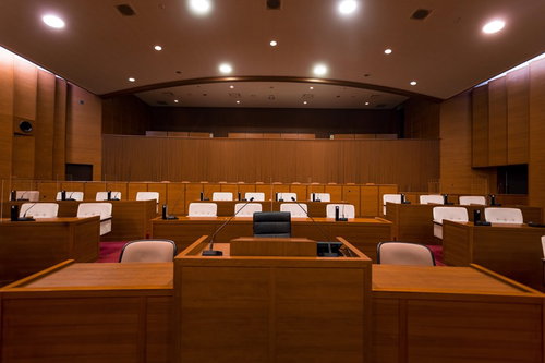 登壇質問の後に質問席に戻る議員が着席する議会の様子