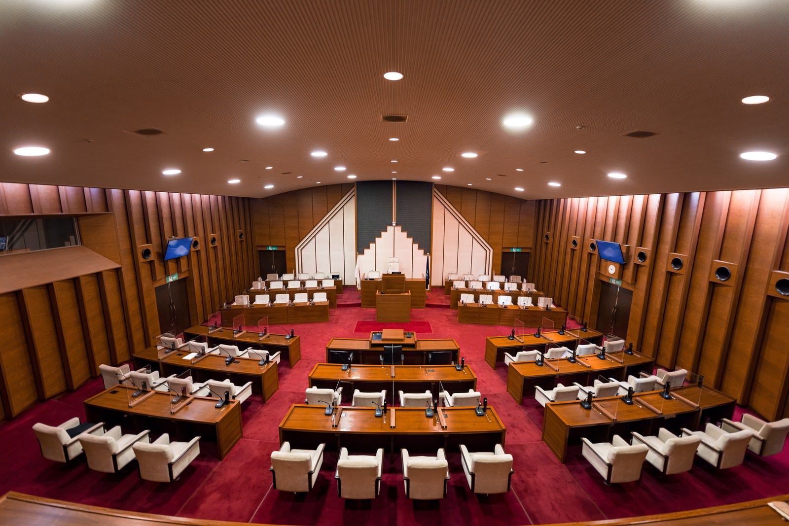 赤い絨毯に木製の議員席が左右対称に配置された津山市議会の議場