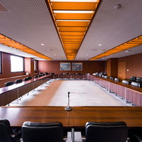 津山市役所議会棟の全員協議会室、オレンジ色の照明と木目調の会議テーブルの写真