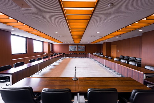 津山市役所議会棟の全員協議会室、オレンジ色の照明と木目調の会議テーブル