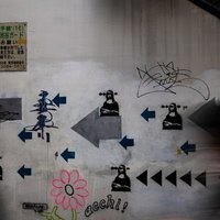 JR東日本高架下に描かれた矢印と人物モチーフの壁画の写真