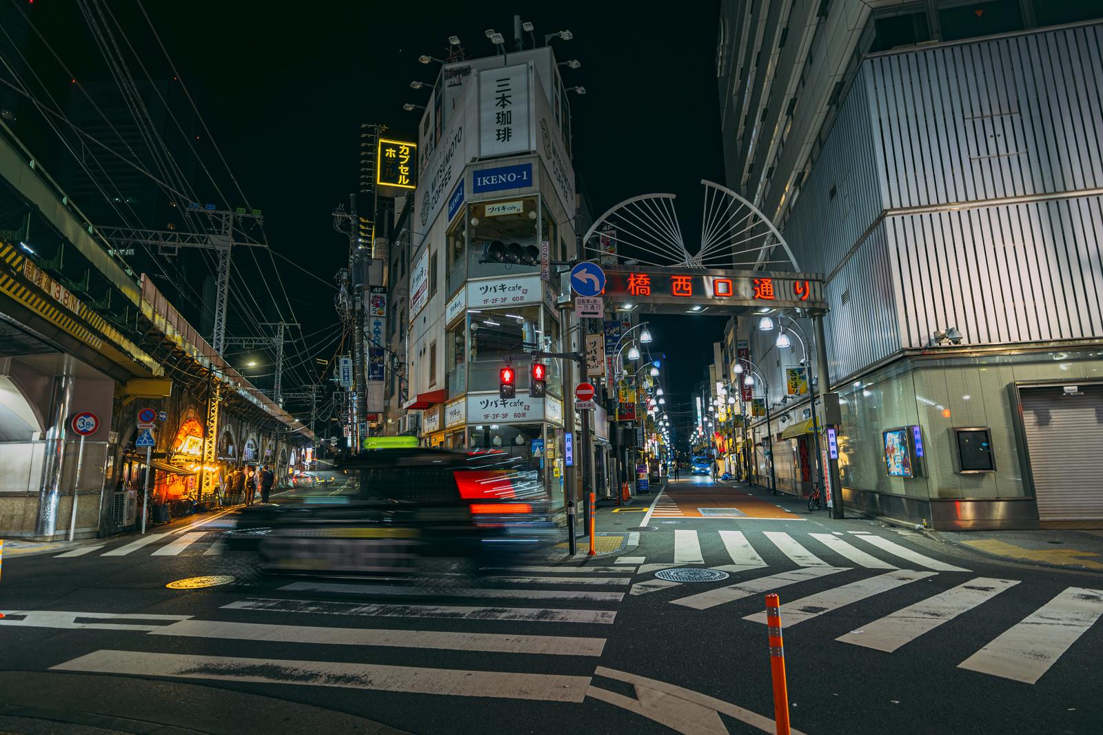 深夜の居酒屋街で赤いネオンが光る新橋西口通りの横断歩道
