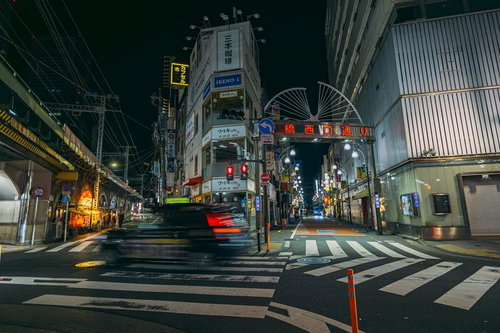 深夜の新橋西口通りを行き交う人々と居酒屋街