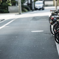 新宿の路地裏に並ぶ駐輪スペースに整列した自転車とバイクの写真