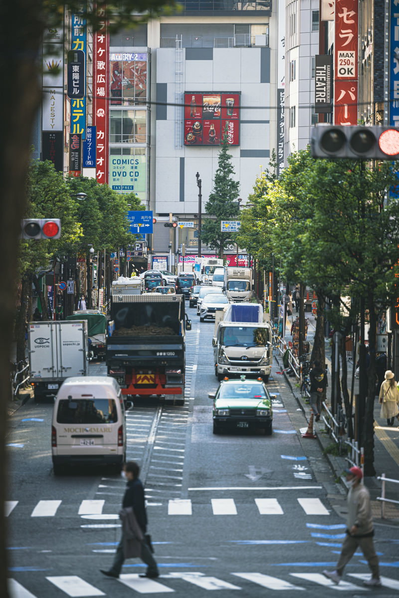 新宿の繁華街で信号待ちするタクシーや車両が並ぶ賑やかな街並み