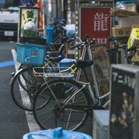新宿の路地裏、店先に並ぶ複数台の自転車と看板の写真