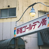 早朝の新宿ゴールデン街、路地裏に佇む青い看板の写真