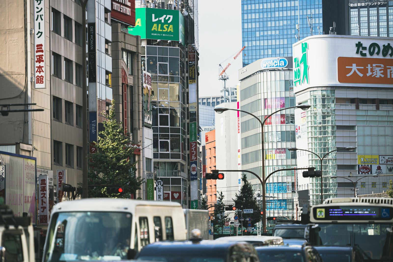 新宿の高層ビル街で赤信号により渋滞している車両の風景