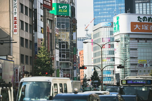 新宿のビル街で赤信号による渋滞と停止する車