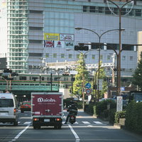 新宿の交差点で信号待ちする車両とバイクの風景の写真