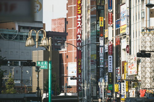 看板だらけの新宿のビル、カラフルな袖看板が密集する都市景観